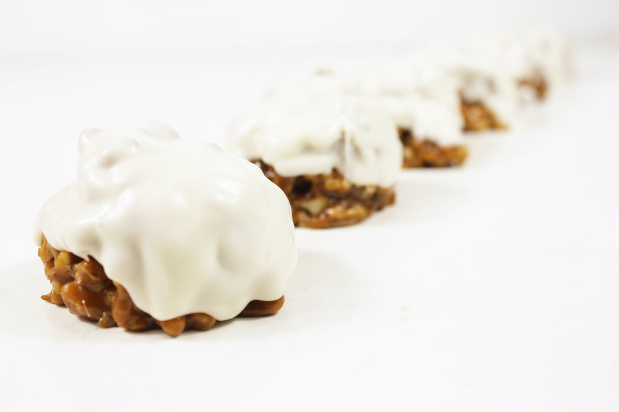 Row of cookies with white icing on a light background